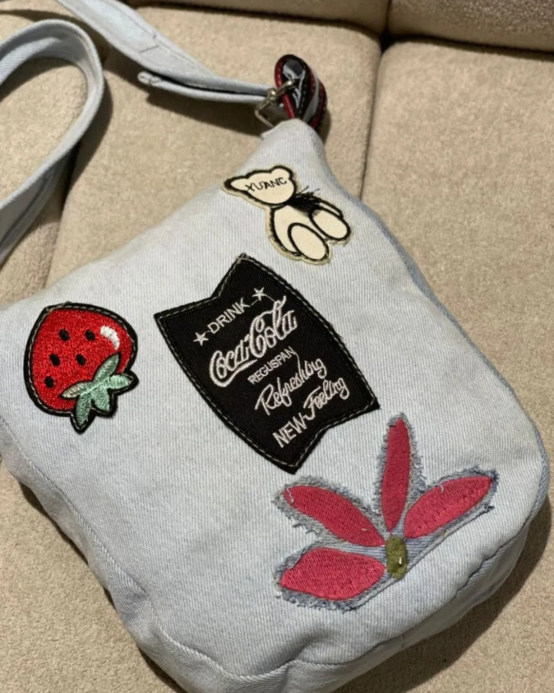 Reborn Patch Denim Crossbody Bag in Glacier Blue is crafted from reclaimed denim with playful patch details secure zip closure and a practical back pocket. A stylish choice for daily wear with a sustainable story