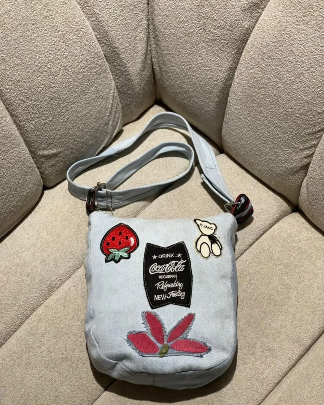 Reborn Patch Denim Crossbody Bag in Glacier Blue is crafted from reclaimed denim with playful patch details secure zip closure and a practical back pocket. A stylish choice for daily wear with a sustainable story